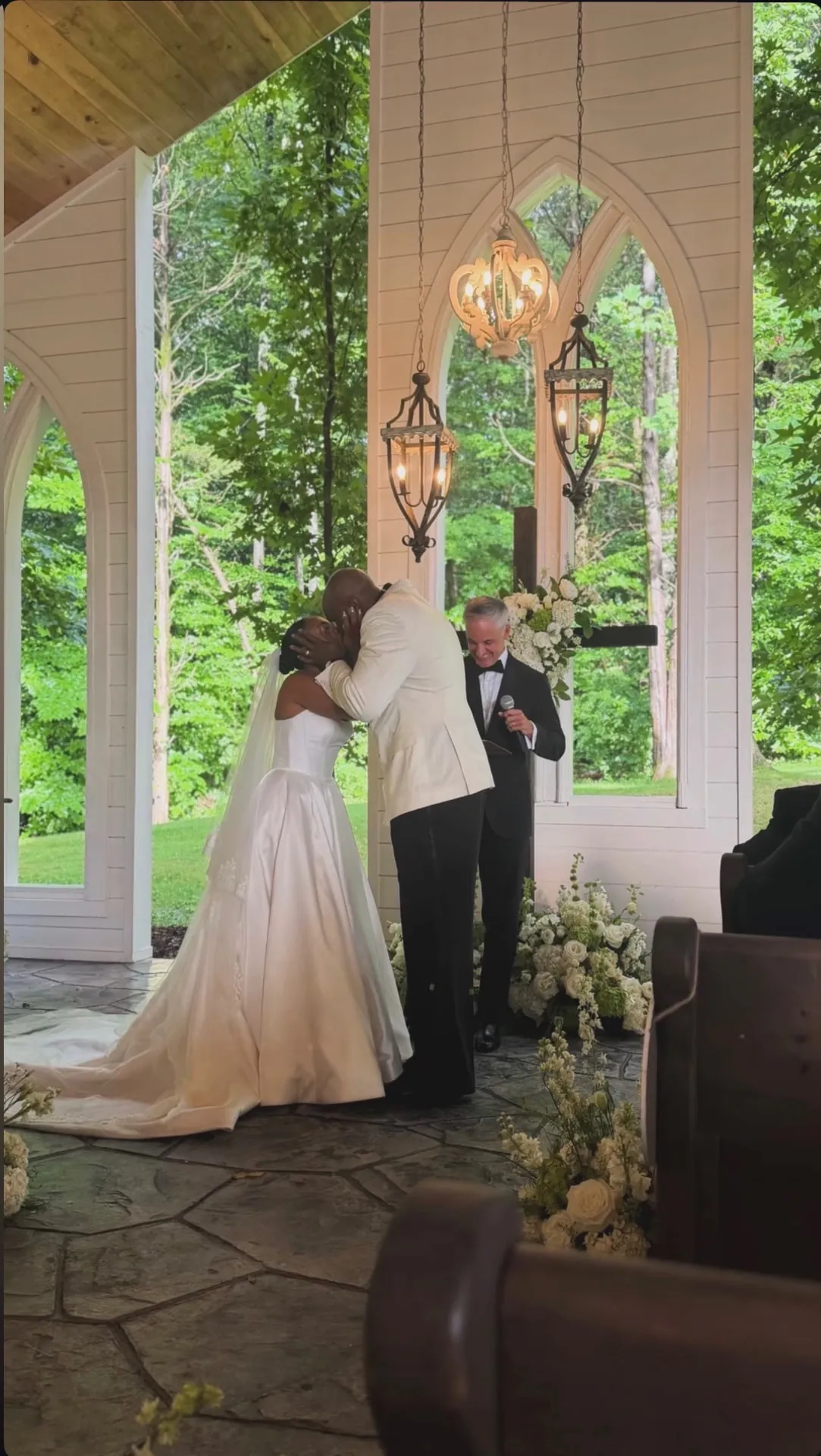 Austin and his wife sharing their first kiss at the altar of their wedding ceremony